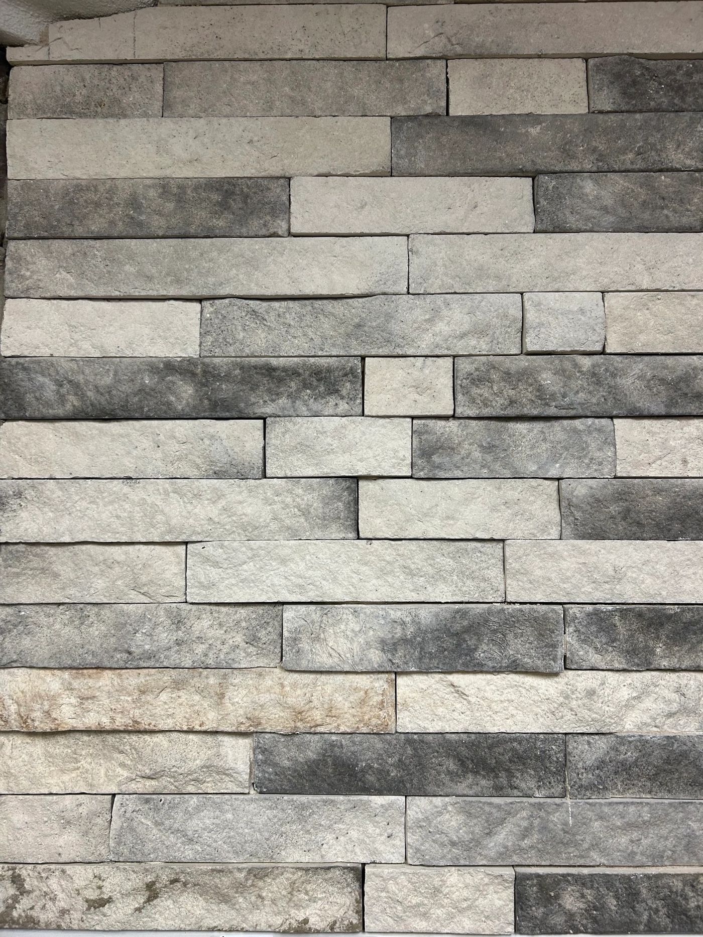 Man-made stacked stone veneer panels in charcoal and gray