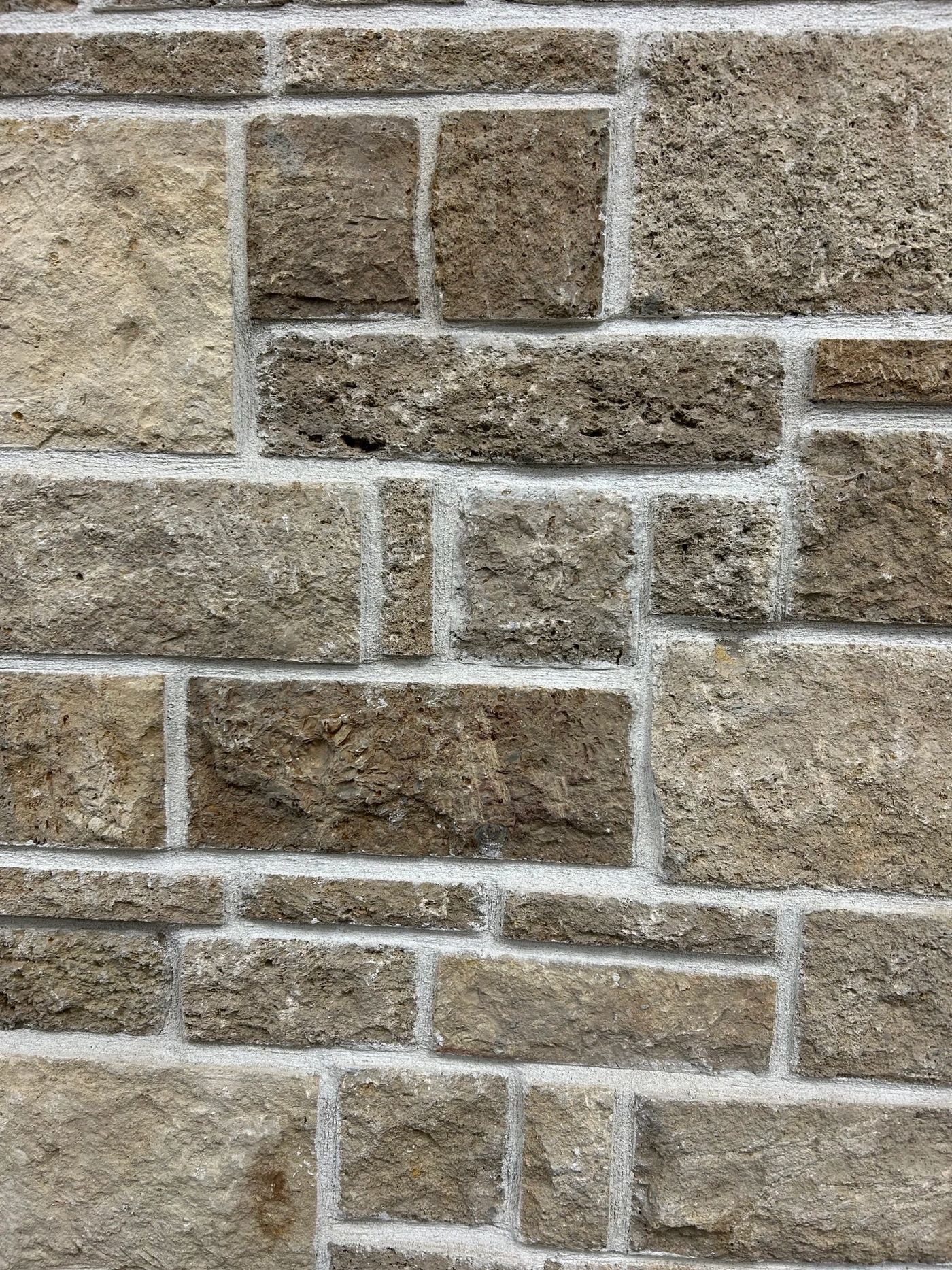 Coursed natural limestone veneer in warm buff tones